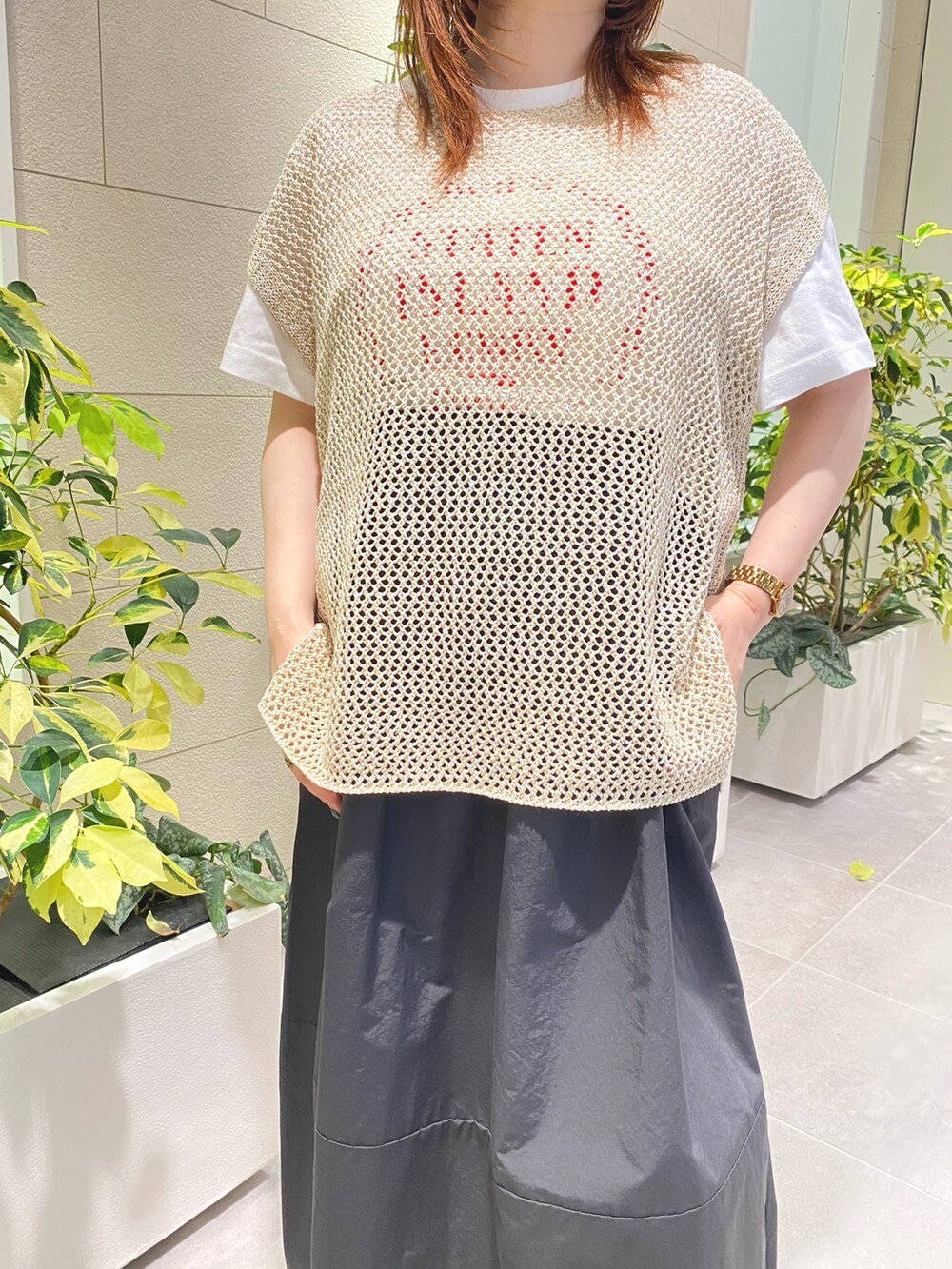 ホワイト系のTシャツ/カットソー、ベージュ系のニット/セーター、ブラック系のスカートを着用したレディースの夏コーディネートの2枚目の写真