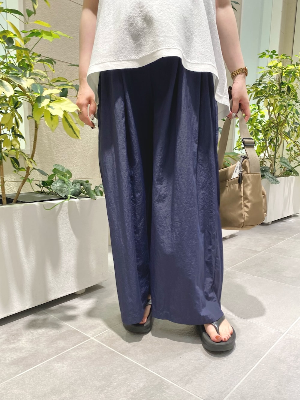 ホワイト系のニット/セーター、ブルー系のその他パンツ、ブラウン系のショルダーバッグを着用したレディースの夏コーディネートの3枚目の写真