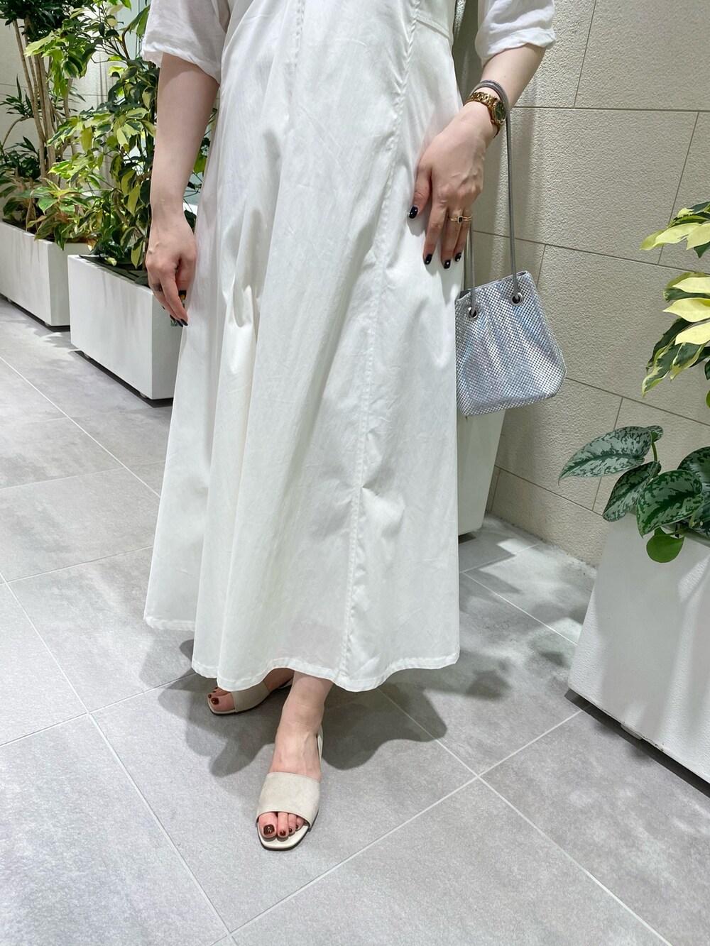 ホワイト系のジャンパースカート、ホワイト系のTシャツ/カットソー、シルバー系のショルダーバッグを着用したレディースの夏コーディネートの3枚目の写真