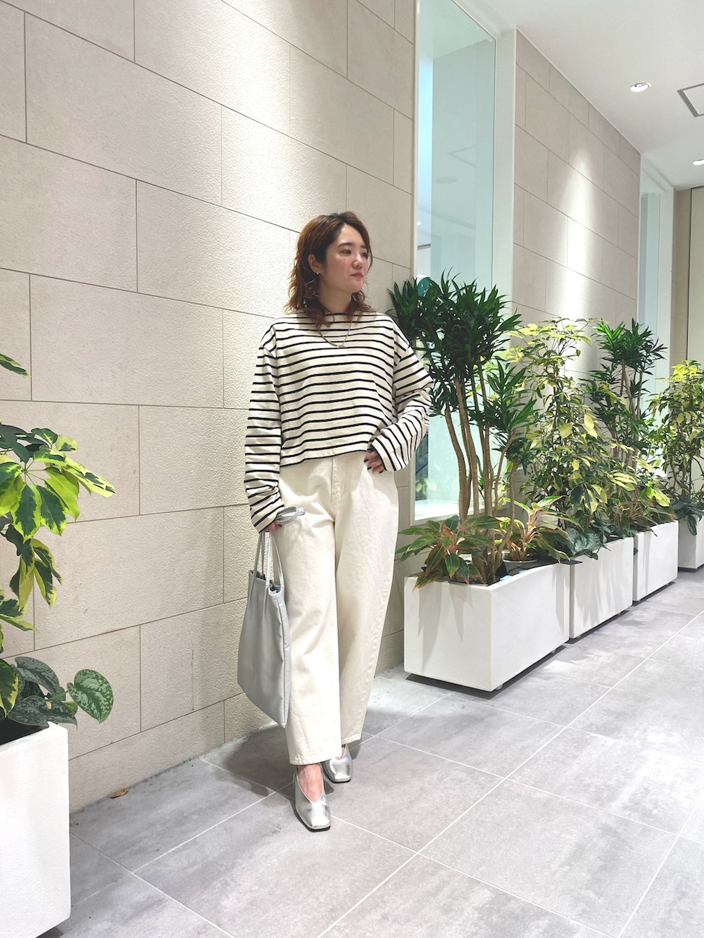 ホワイト系のTシャツ/カットソー、シルバー系のトートバッグ、ホワイト系のデニムパンツを着用したレディースの夏コーディネートの2枚目の写真