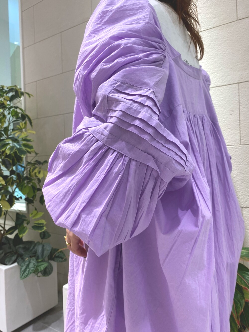 パープル系のワンピース、ホワイト系のデニムパンツ、ホワイト系のローファーを着用したレディースの夏コーディネートの2枚目の写真