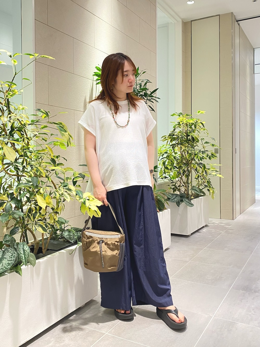 ホワイト系のニット/セーター、ブルー系のその他パンツ、ブラウン系のショルダーバッグを着用したレディースの夏コーディネートの2枚目の写真