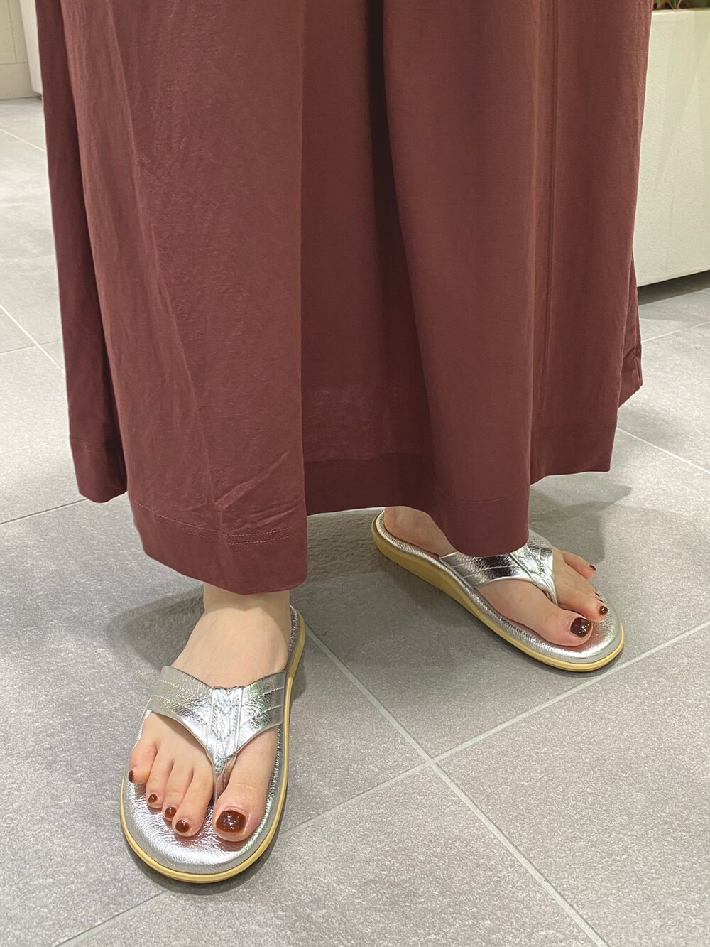 ブラウン系のワンピース、ベージュ系のショルダーバッグ、シルバー系のサンダルを着用したレディースの夏コーディネートの2枚目の写真