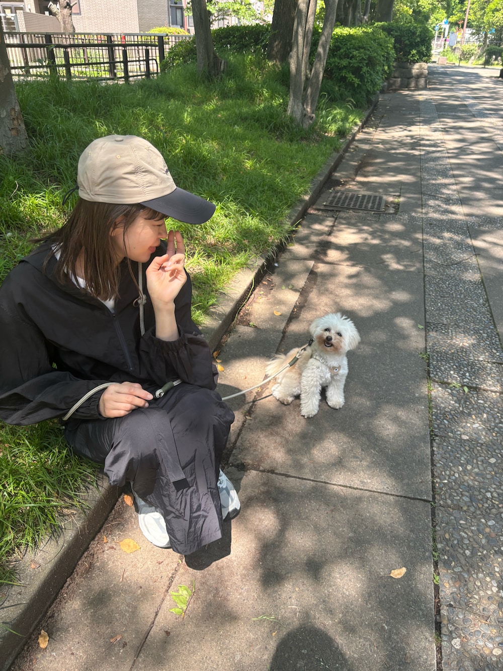 ブラック系のスカート、ブラック系のパーカー、グレー系のスニーカーを着用したレディースの春コーディネートの2枚目の写真