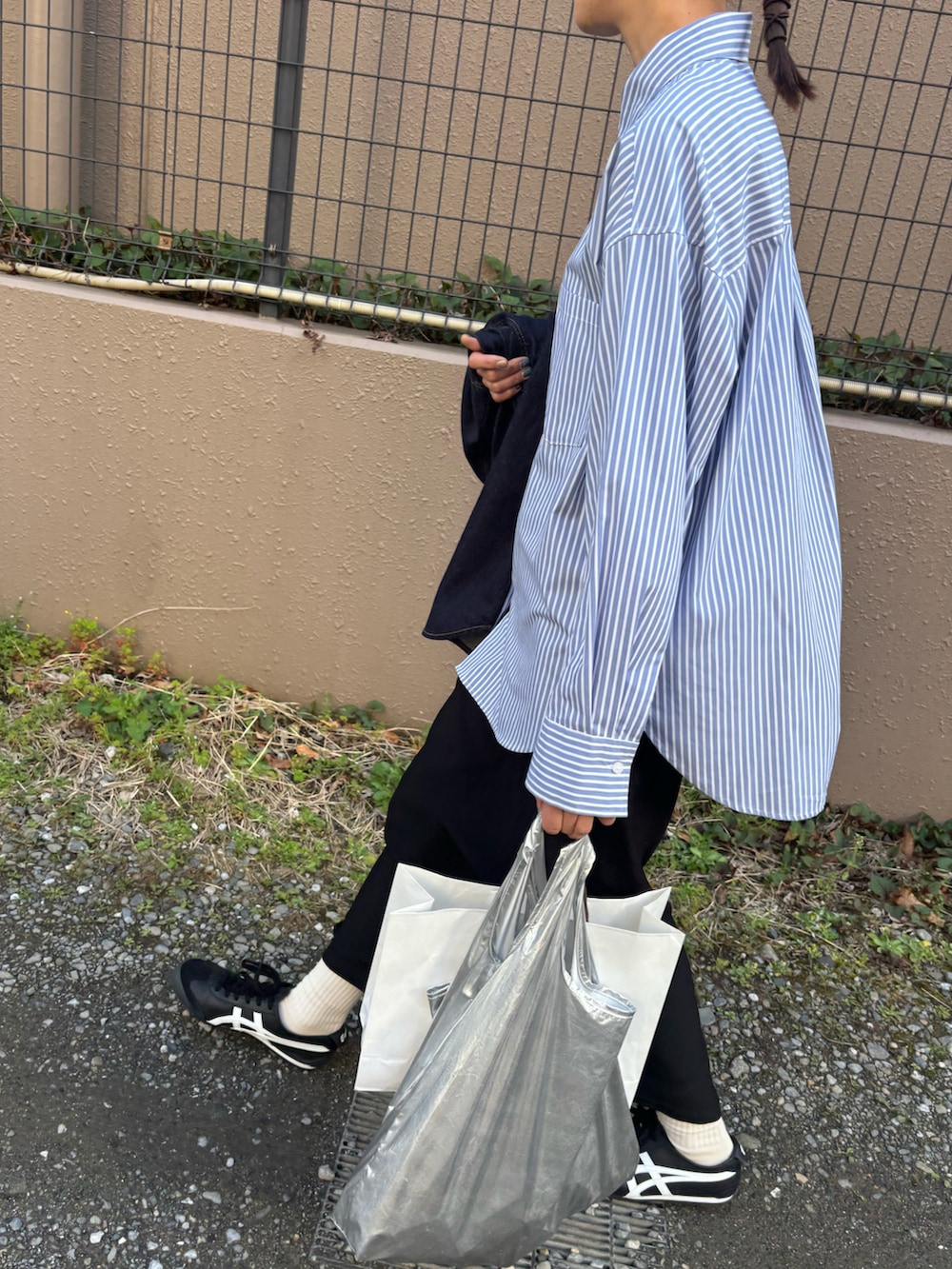 ブルー系のシャツ/ブラウス、ブラック系のスニーカーを着用したレディースの春コーディネートの2枚目の写真