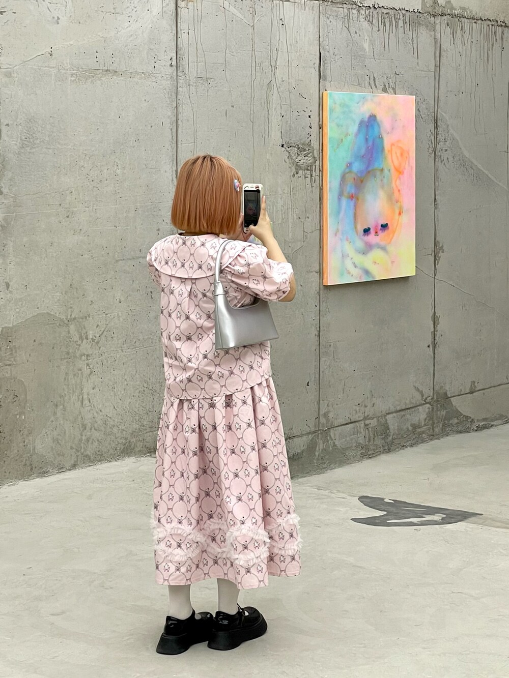 ピンク系のシャツ/ブラウス、ピンク系のスカート、シルバー系のショルダーバッグを着用したレディースの秋コーディネートの2枚目の写真