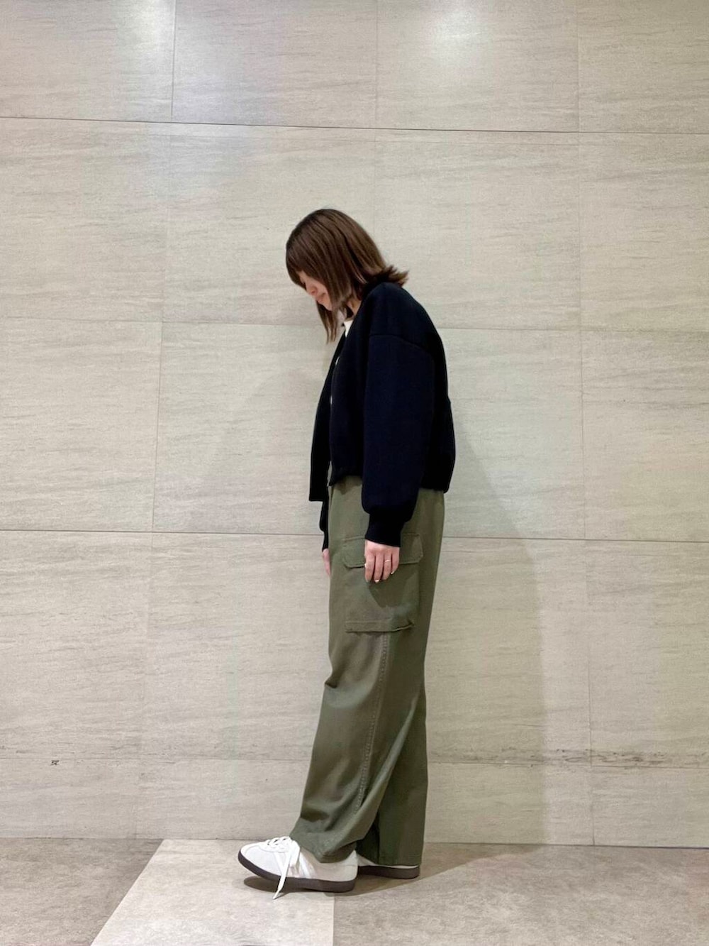 ホワイト系のTシャツ/カットソー、グリーン系のカーゴパンツ、ホワイト系のスニーカーを着用したレディースの秋コーディネートの4枚目の写真