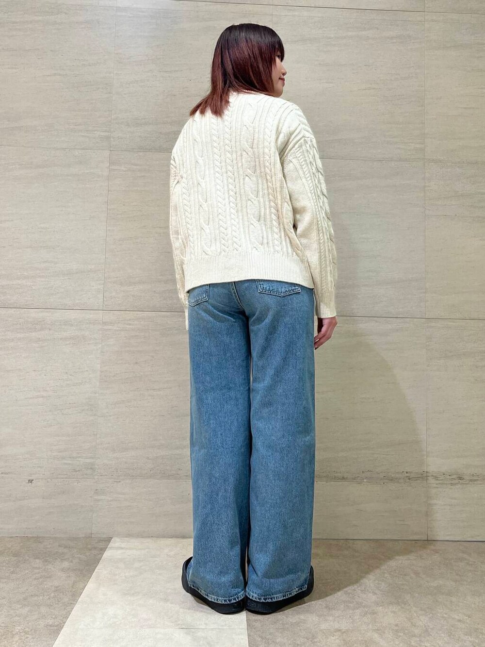 ホワイト系のカーディガン/ボレロ、イエロー系のニット/セーター、ブルー系のデニムパンツを着用したレディースの冬コーディネートの4枚目の写真