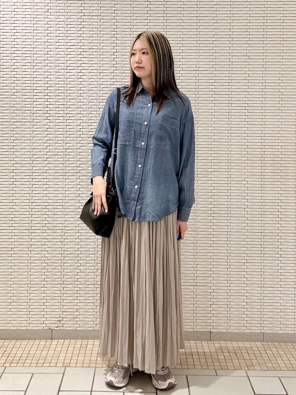 ブルー系のシャツ/ブラウス、ブラック系のバッグ、ベージュ系のスカートを着用したレディースの春コーディネートの2枚目の写真