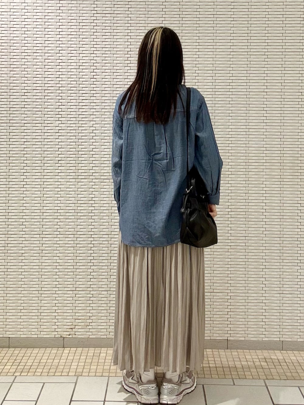 ブルー系のシャツ/ブラウス、ブラック系のバッグ、ベージュ系のスカートを着用したレディースの春コーディネートの3枚目の写真