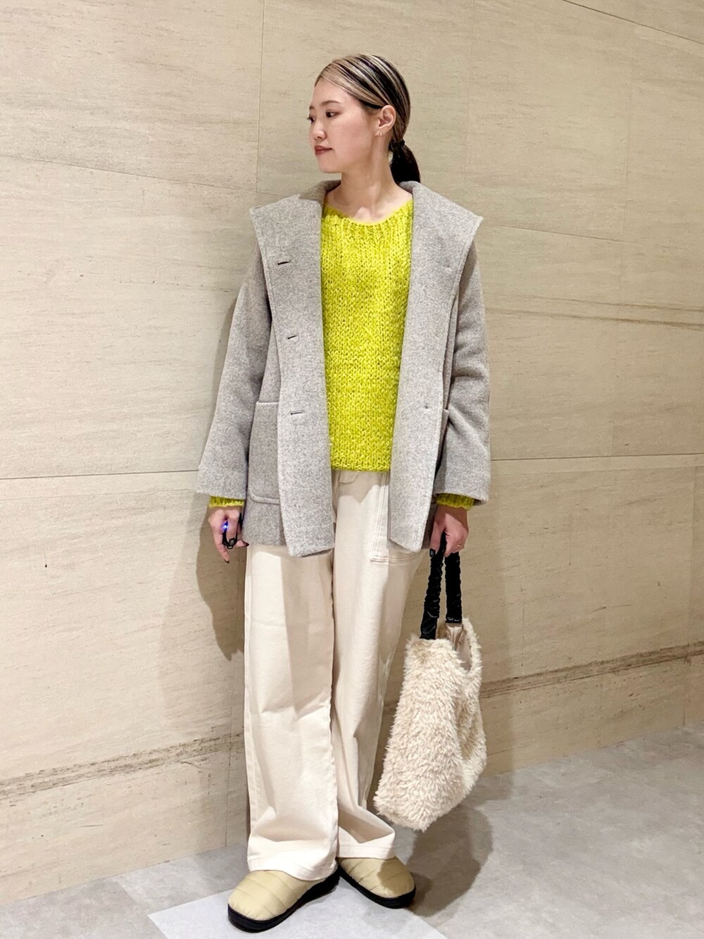 イエロー系のニット/セーター、ベージュ系のその他アウター、ホワイト系のその他パンツを着用したレディースの秋コーディネートの2枚目の写真