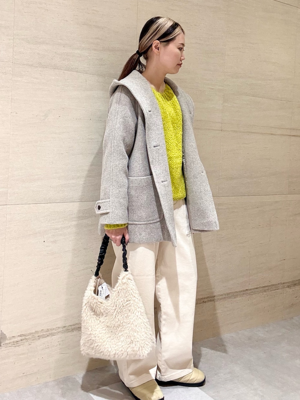 イエロー系のニット/セーター、ベージュ系のその他アウター、ホワイト系のその他パンツを着用したレディースの秋コーディネートの3枚目の写真
