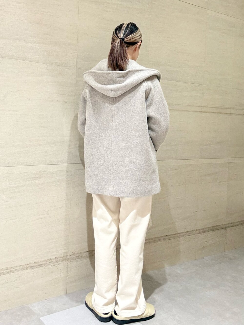 イエロー系のニット/セーター、ベージュ系のその他アウター、ホワイト系のその他パンツを着用したレディースの秋コーディネートの4枚目の写真