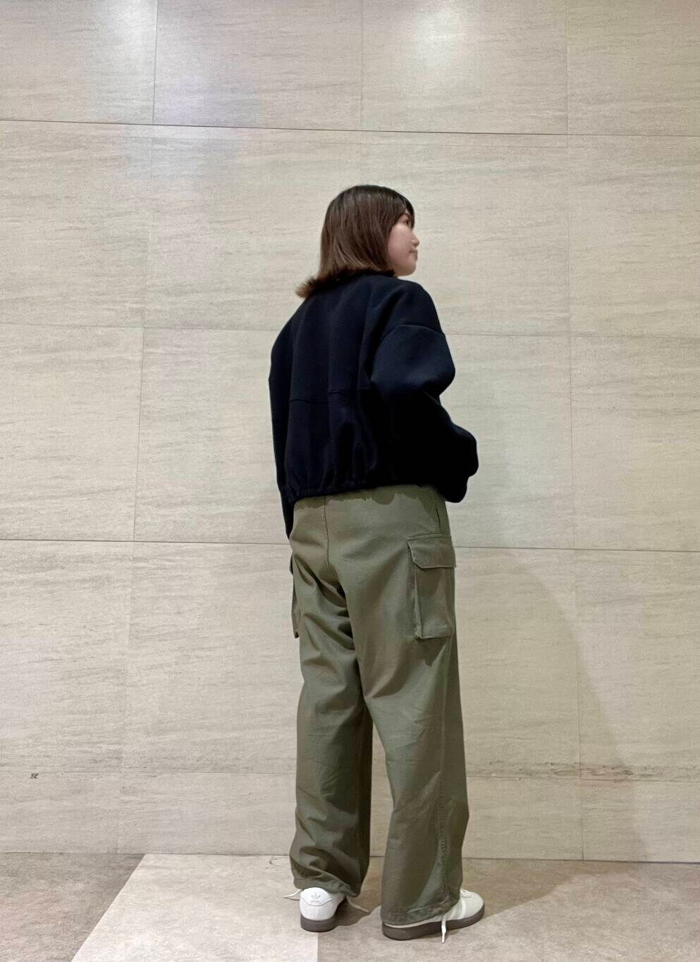 ホワイト系のTシャツ/カットソー、グリーン系のカーゴパンツ、ホワイト系のスニーカーを着用したレディースの秋コーディネートの5枚目の写真
