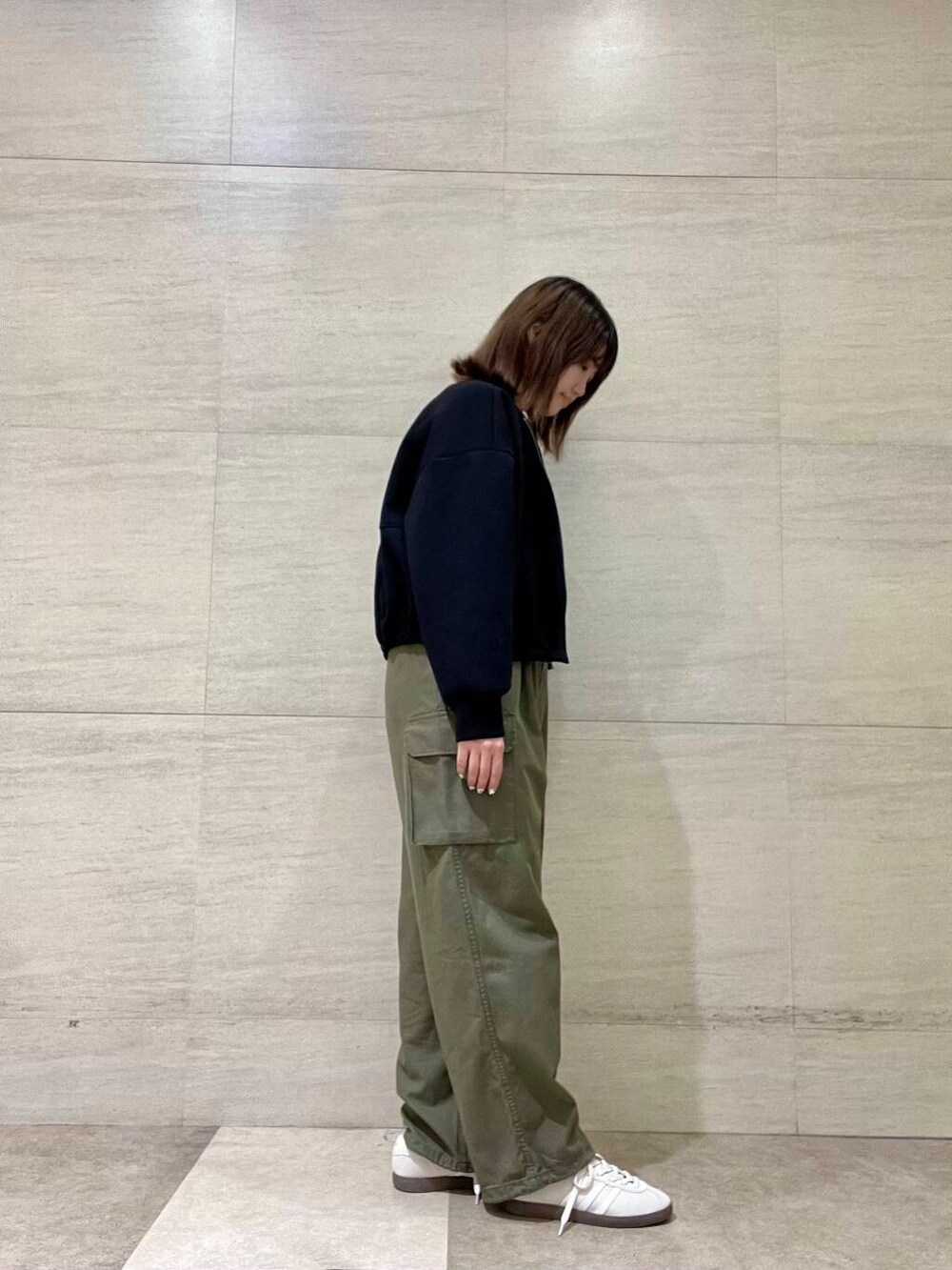 ホワイト系のTシャツ/カットソー、グリーン系のカーゴパンツ、ホワイト系のスニーカーを着用したレディースの秋コーディネートの3枚目の写真