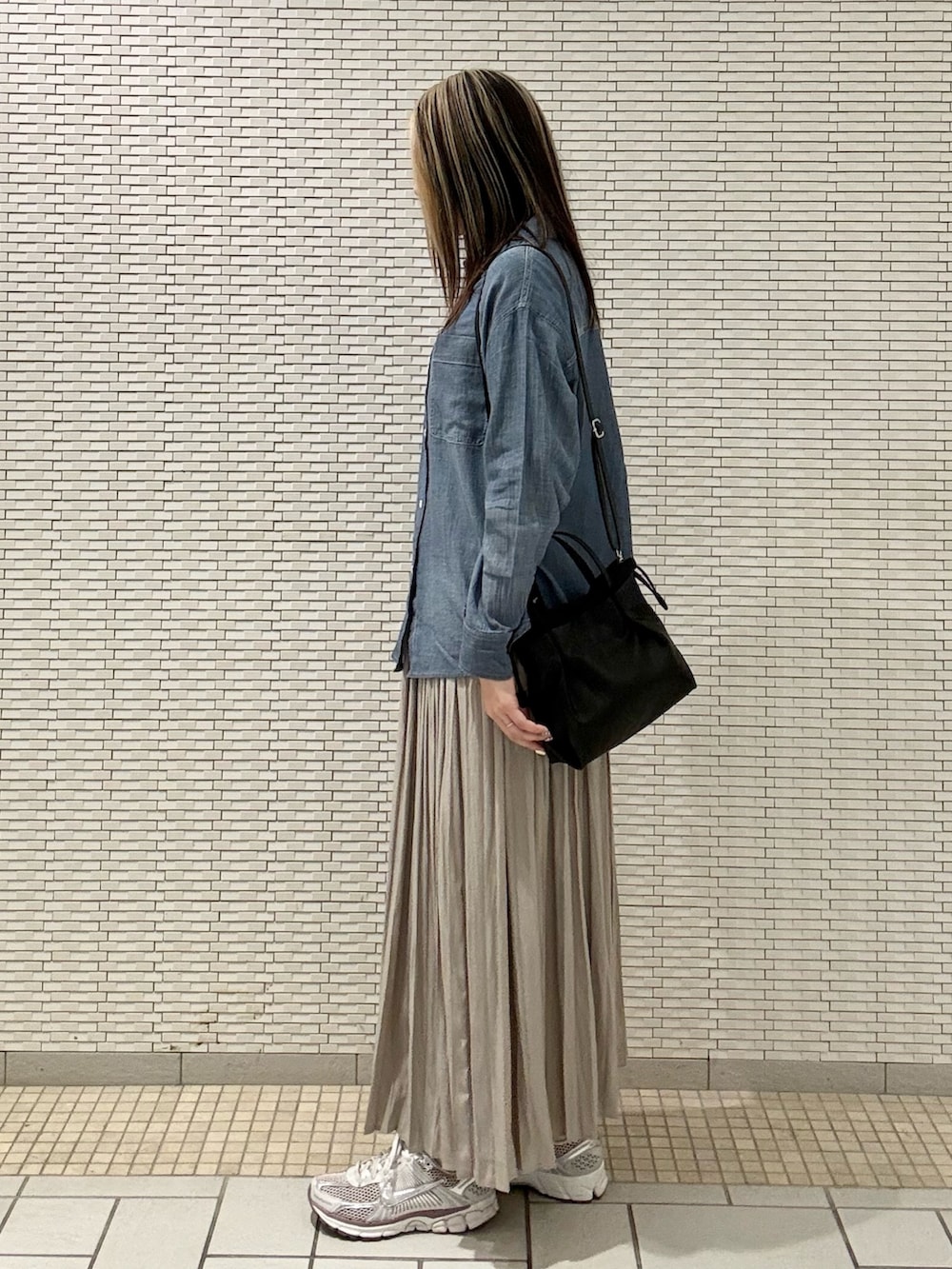 ブルー系のシャツ/ブラウス、ブラック系のバッグ、ベージュ系のスカートを着用したレディースの春コーディネートの4枚目の写真