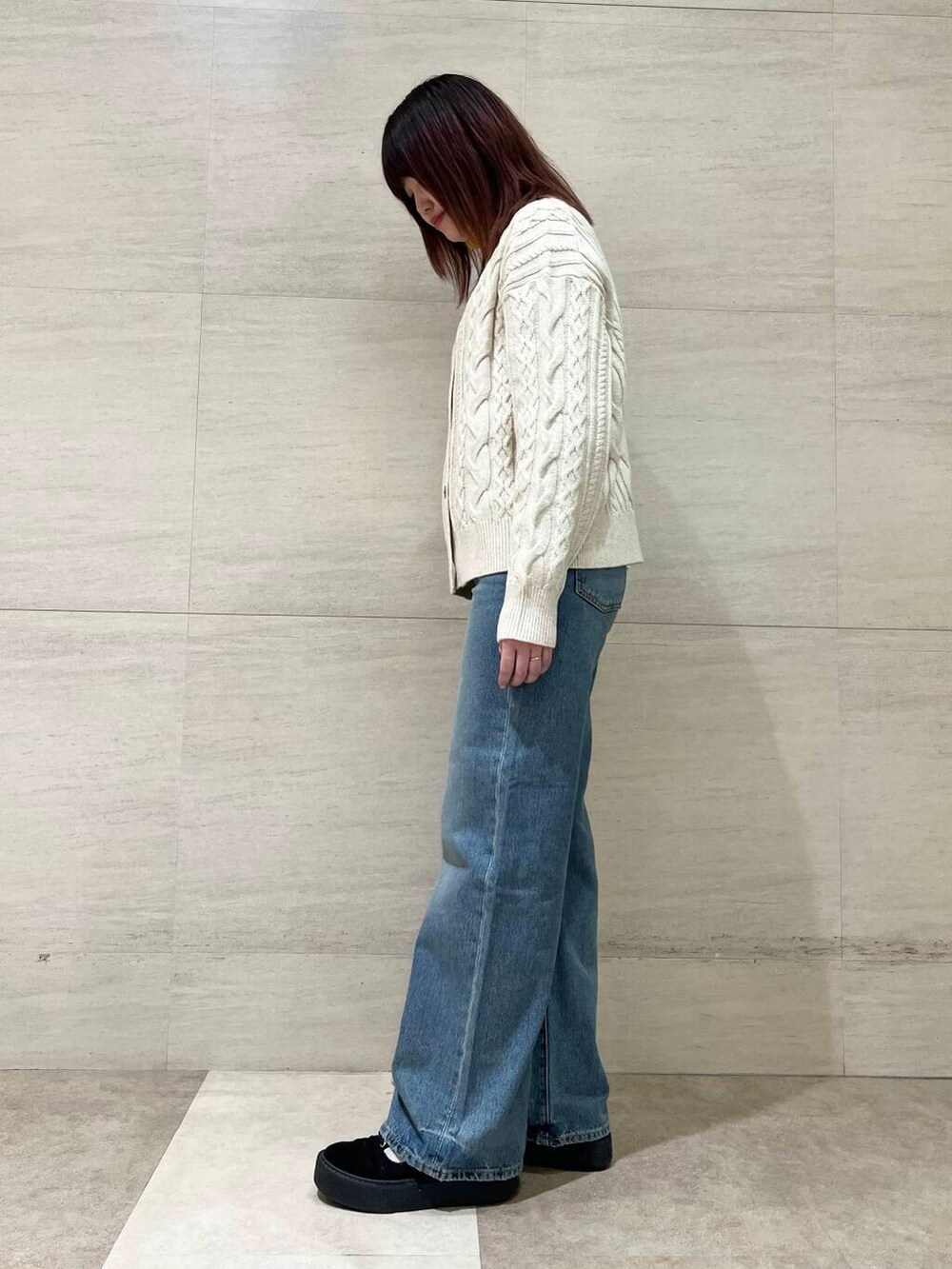 ホワイト系のカーディガン/ボレロ、イエロー系のニット/セーター、ブルー系のデニムパンツを着用したレディースの冬コーディネートの5枚目の写真