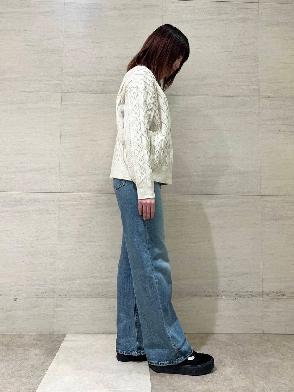 ホワイト系のカーディガン/ボレロ、イエロー系のニット/セーター、ブルー系のデニムパンツを着用したレディースの冬コーディネートの3枚目の写真