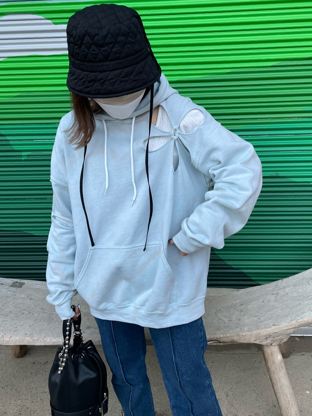 ブラック系のショルダーバッグ、ブルー系のデニムパンツ、グレー系のスニーカーを着用したレディースの春コーディネートの2枚目の写真