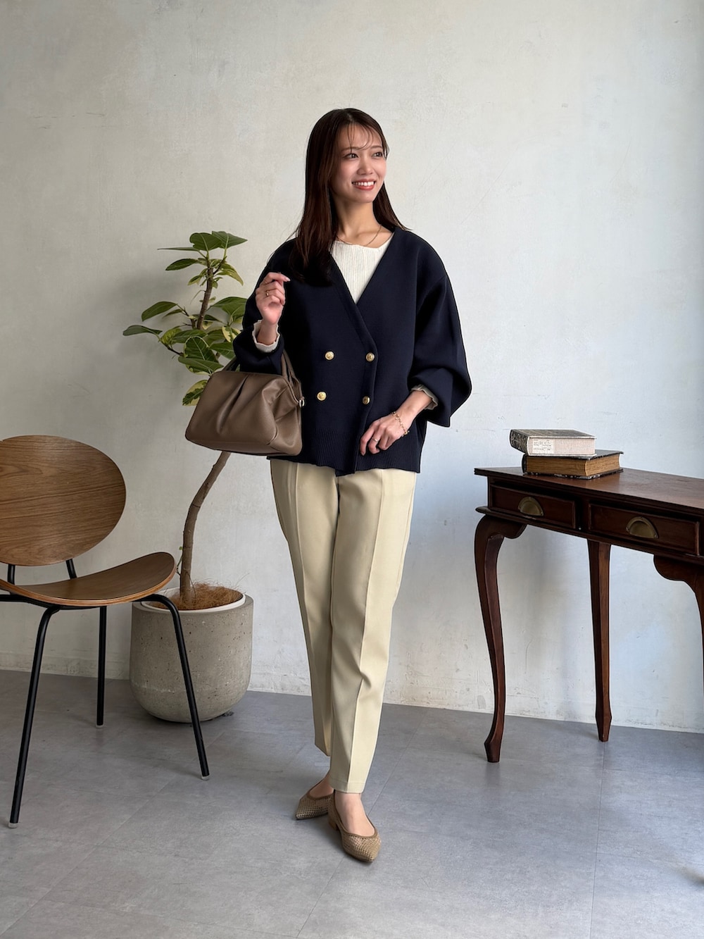 ブルー系のカーディガン/ボレロ、ホワイト系のニット/セーター、ベージュ系のその他パンツを着用したレディースの春コーディネートの2枚目の写真