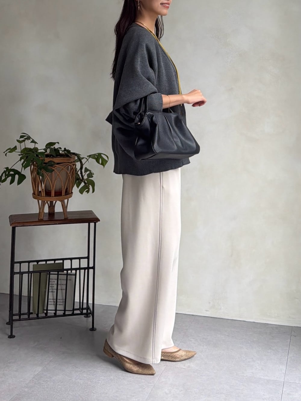 グレー系のカーディガン/ボレロ、イエロー系のシャツ/ブラウス、ホワイト系のその他パンツを着用したレディースの秋コーディネートの4枚目の写真