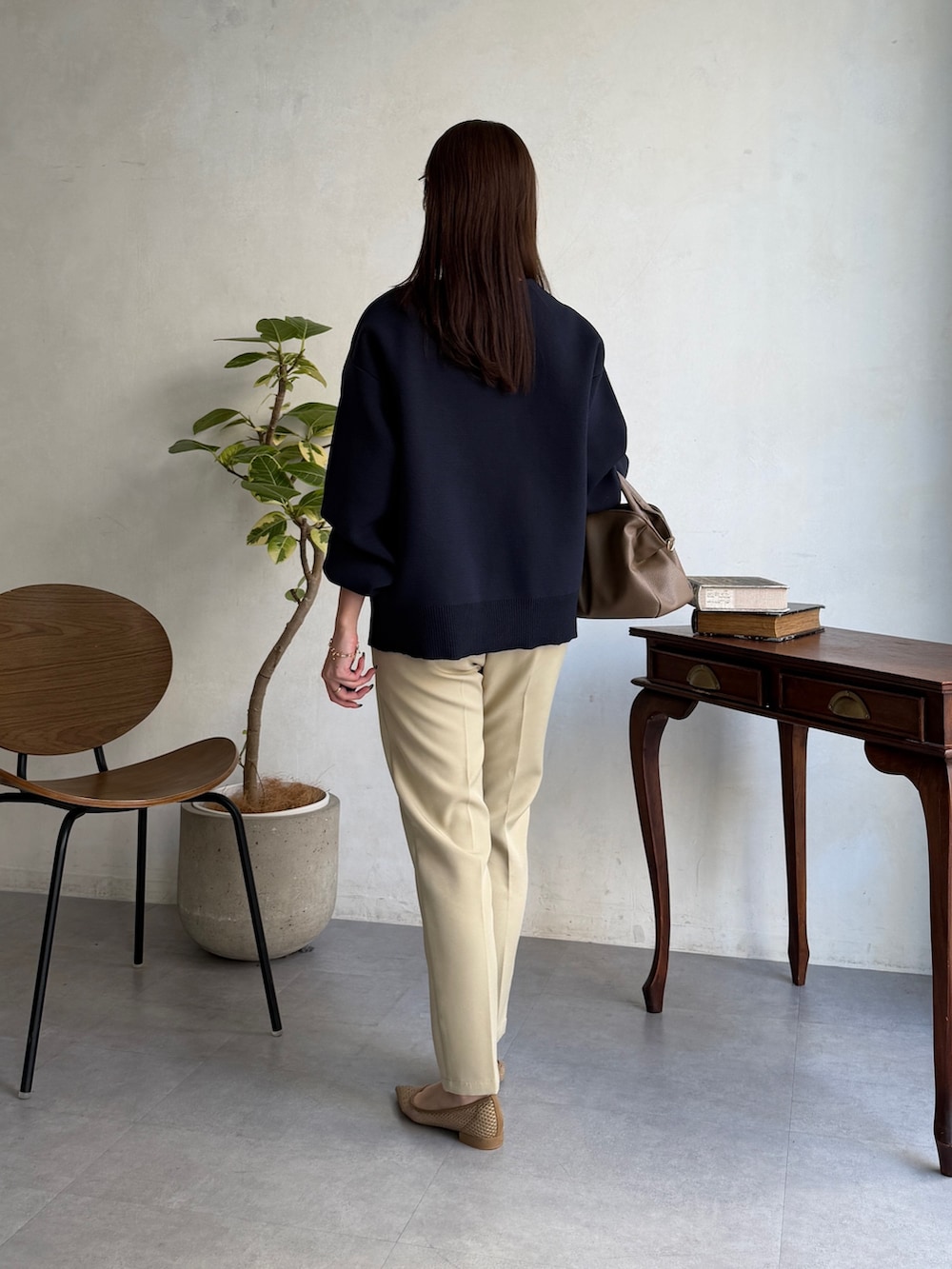 ブルー系のカーディガン/ボレロ、ホワイト系のニット/セーター、ベージュ系のその他パンツを着用したレディースの春コーディネートの4枚目の写真