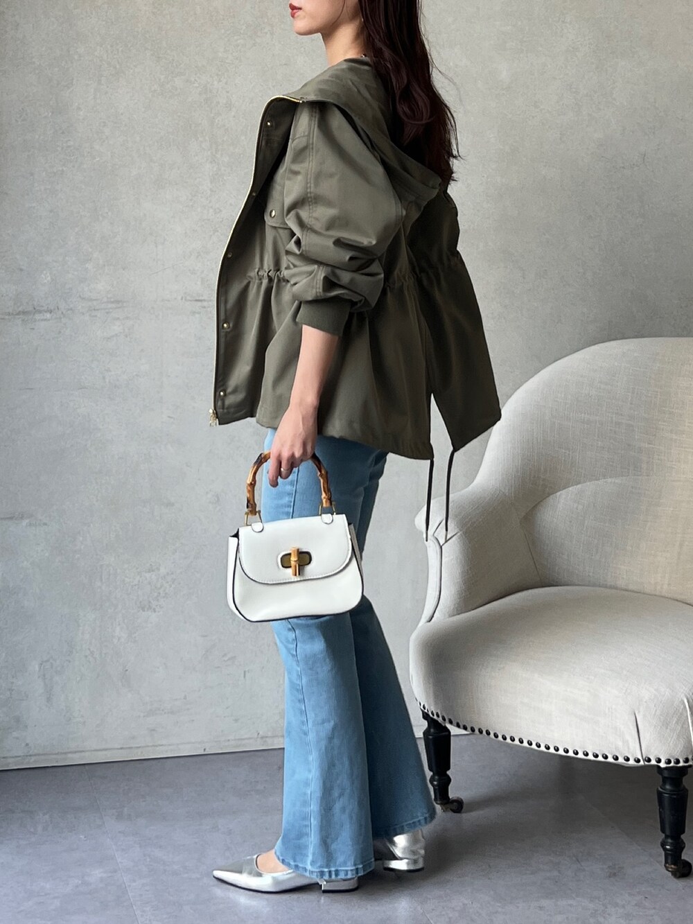 グリーン系のブルゾン、ホワイト系のシャツ/ブラウス、ブルー系のデニムパンツを着用したレディースの冬コーディネートの5枚目の写真