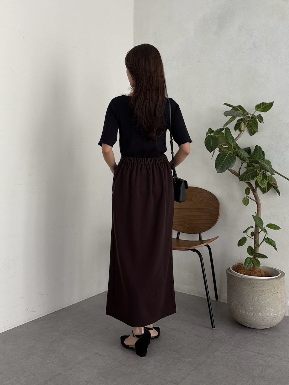 ブラック系のニット/セーター、ブラウン系のスカート、ブラック系のサンダルを着用したレディースの夏コーディネートの3枚目の写真