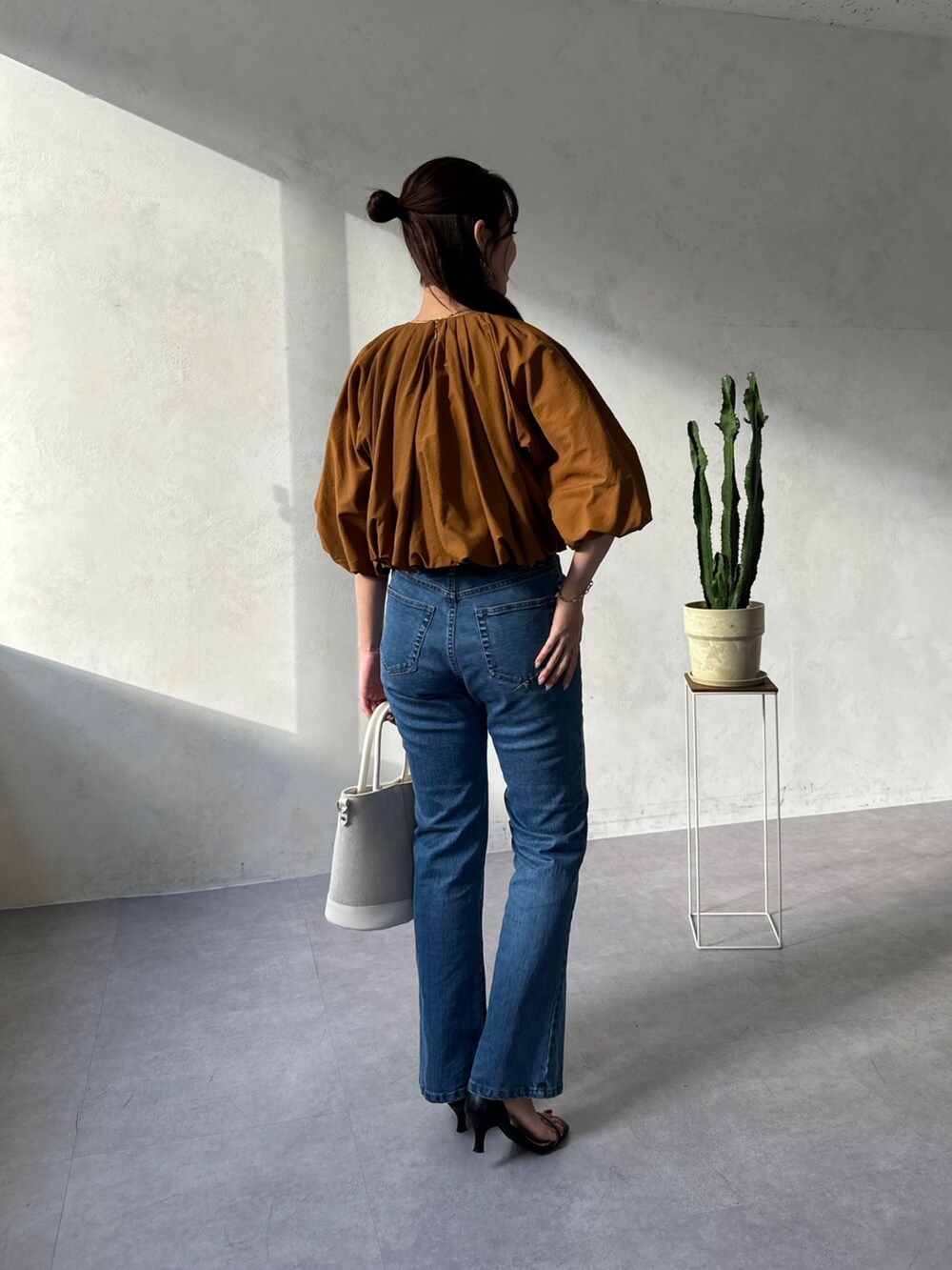 イエロー系のシャツ/ブラウス、ブルー系のデニムパンツ、ホワイト系のトートバッグを着用したレディースの春コーディネートの3枚目の写真