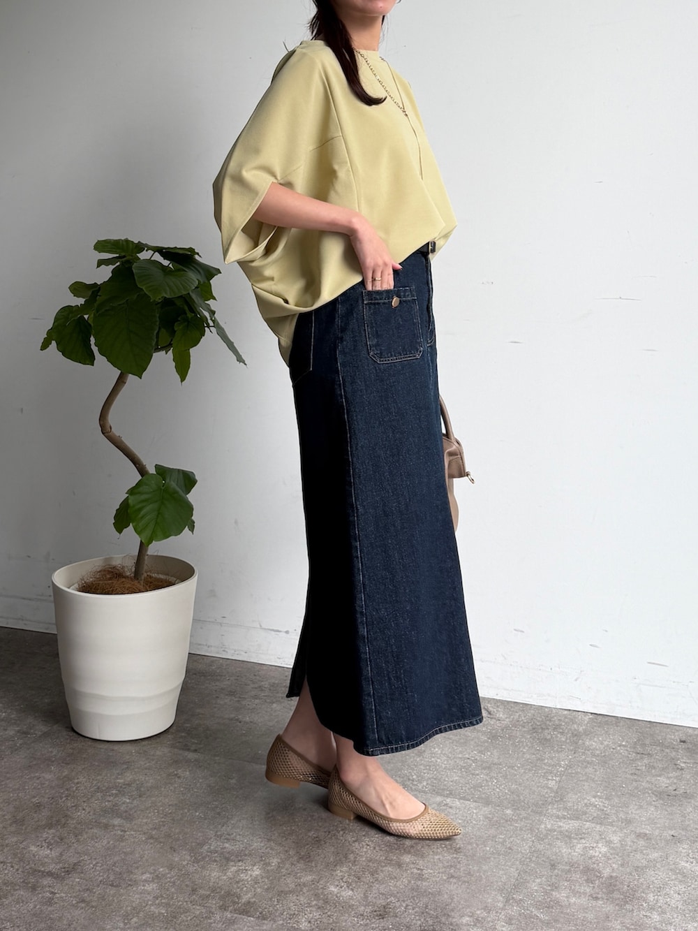 グリーン系のTシャツ/カットソー、ブルー系のスカート、ベージュ系のボストンバッグを着用したレディースの春コーディネートの3枚目の写真