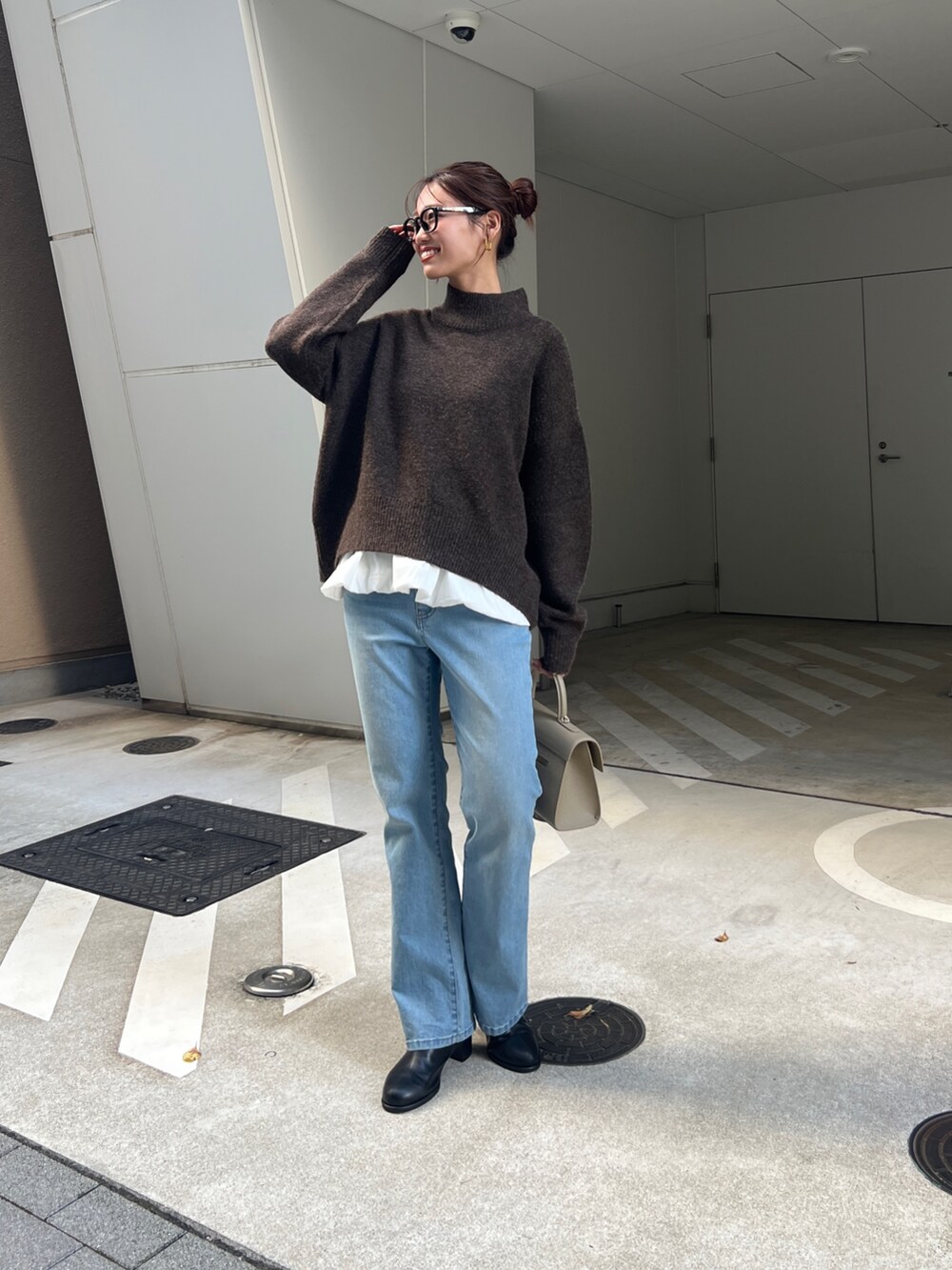 ブラウン系のニット/セーター、グレー系のカーディガン/ボレロ、ブルー系のデニムパンツを着用したレディースの秋コーディネートの4枚目の写真