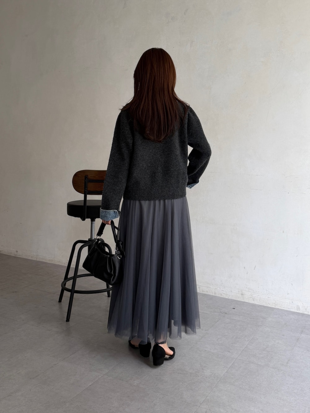 グレー系のカーディガン/ボレロ、グレー系のスカート、ブラック系のショルダーバッグを着用したレディースの秋コーディネートの3枚目の写真