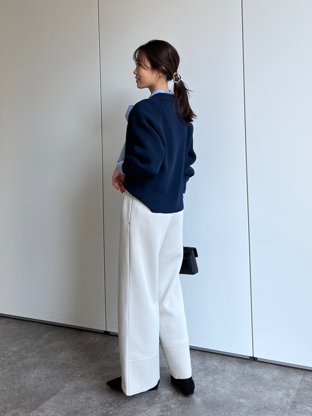 ブルー系のニット/セーター、ブルー系のシャツ/ブラウス、ホワイト系のその他パンツを着用したレディースの冬コーディネートの2枚目の写真