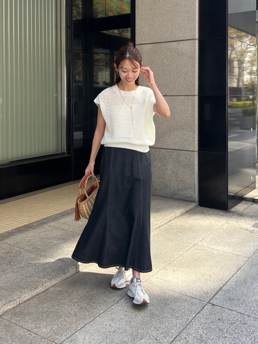 ホワイト系のニット/セーター、ブラック系のスカート、ベージュ系のかごバッグを着用したレディースの春コーディネートの5枚目の写真
