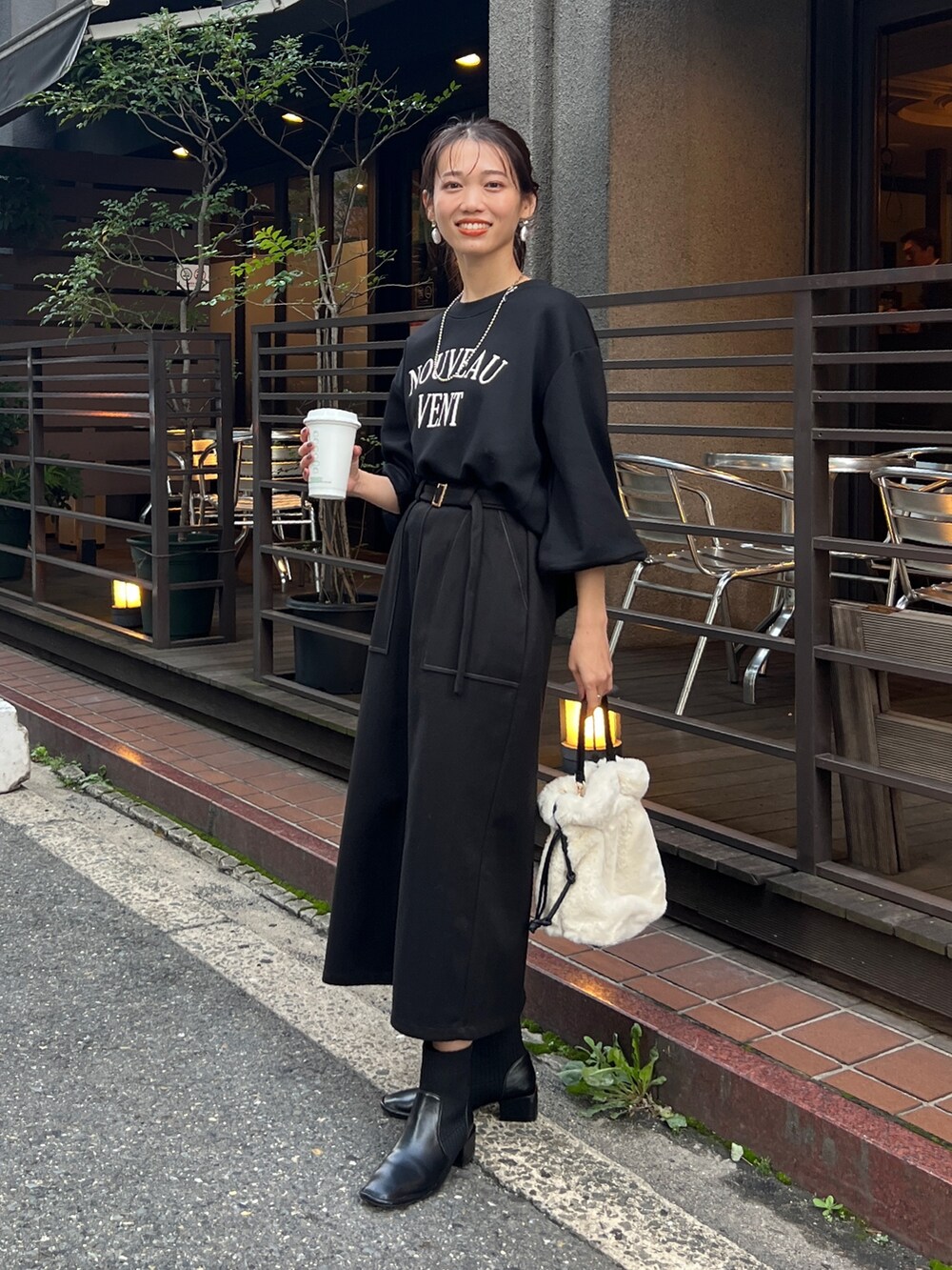 ブラック系のスカート、ブラック系のダウンジャケット/コート、ブラック系のスウェットを着用したレディースの秋コーディネートの2枚目の写真