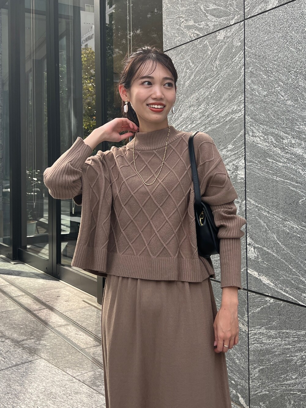 ブラウン系のワンピース、ブラック系のブーツ、ゴールド系のネックレスを着用したレディースの秋コーディネートの3枚目の写真