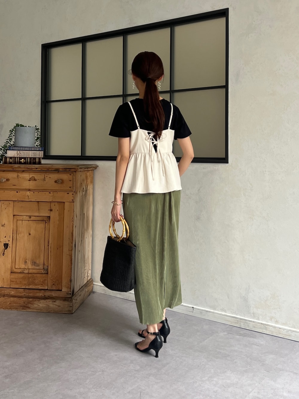 ホワイト系のワンピース、ブラック系のTシャツ/カットソー、グリーン系のスカートを着用したレディースの春コーディネートの2枚目の写真