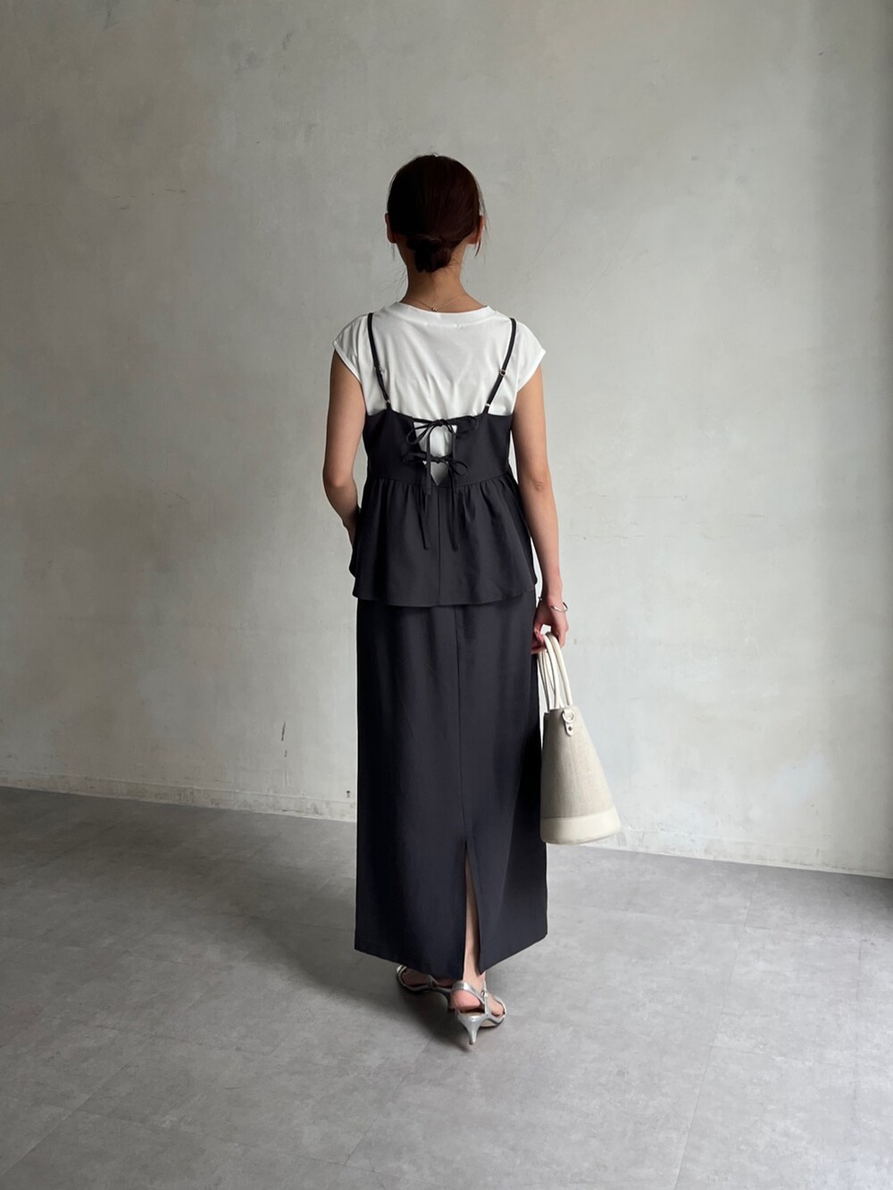 グレー系のワンピース、ホワイト系のトートバッグ、シルバー系のサンダルを着用したレディースの春コーディネートの3枚目の写真