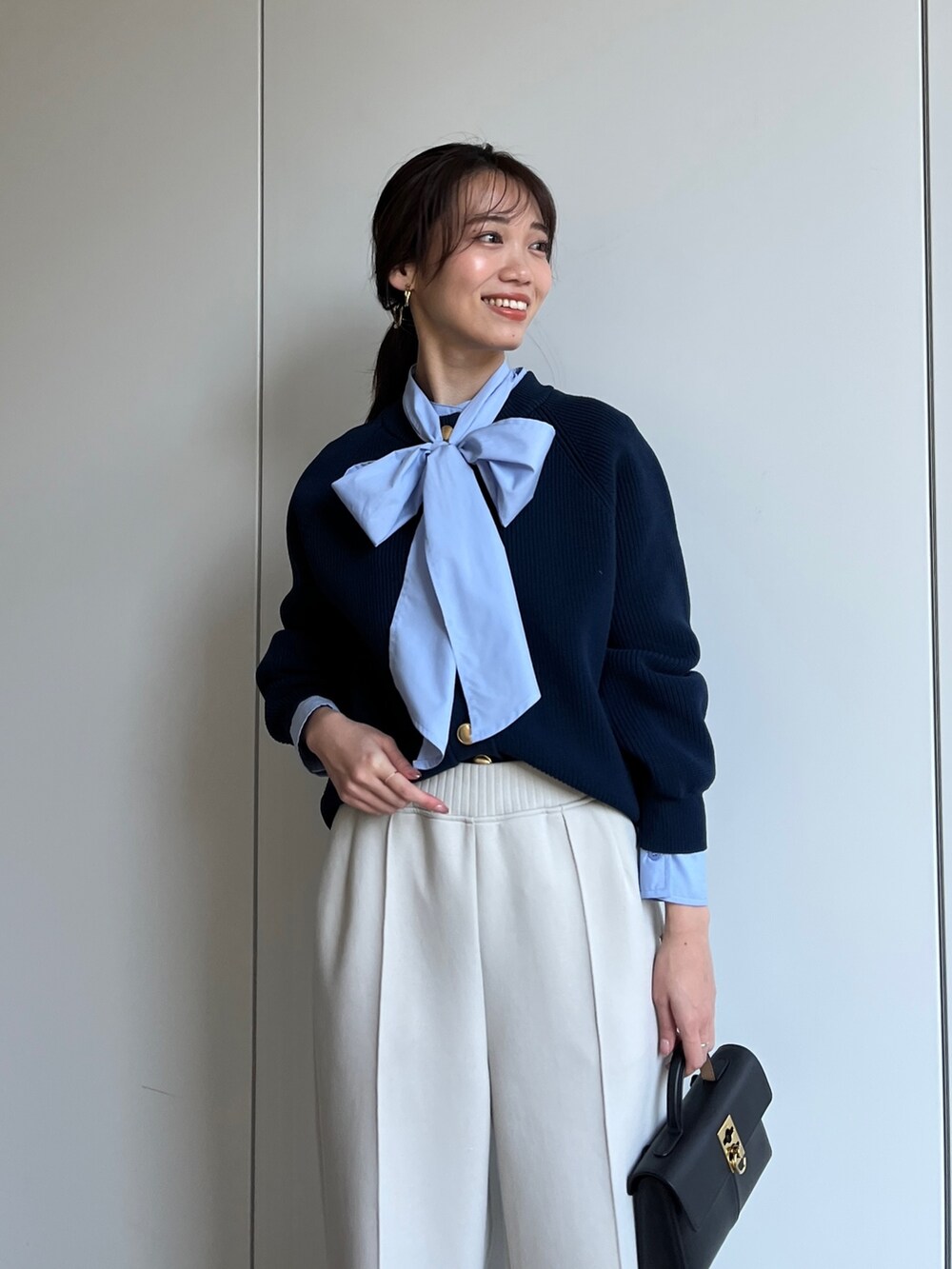 ブルー系のニット/セーター、ブルー系のシャツ/ブラウス、ホワイト系のその他パンツを着用したレディースの冬コーディネートの3枚目の写真