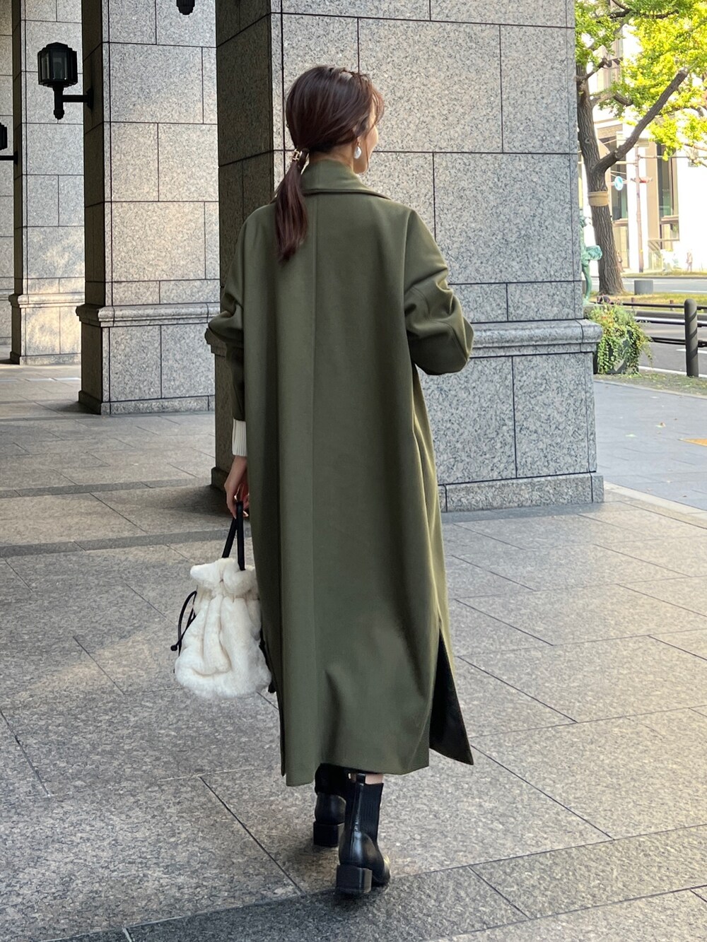 グリーン系のその他アウター、ブラック系のスカート、ホワイト系のトートバッグを着用したレディースの秋コーディネートの2枚目の写真