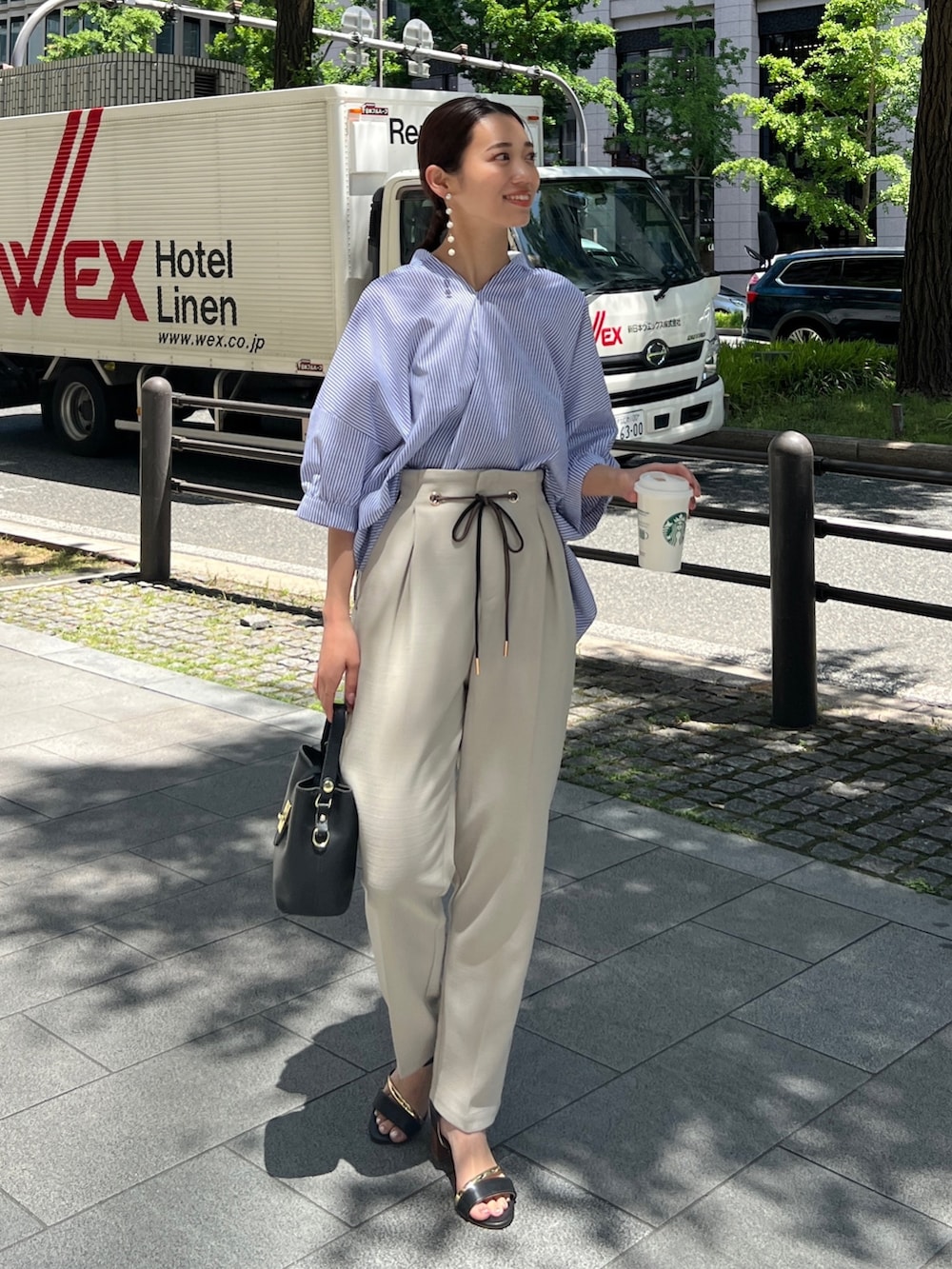 ホワイト系のシャツ/ブラウス、ベージュ系のその他パンツ、ブラック系のサンダルを着用したレディースの春コーディネートの2枚目の写真