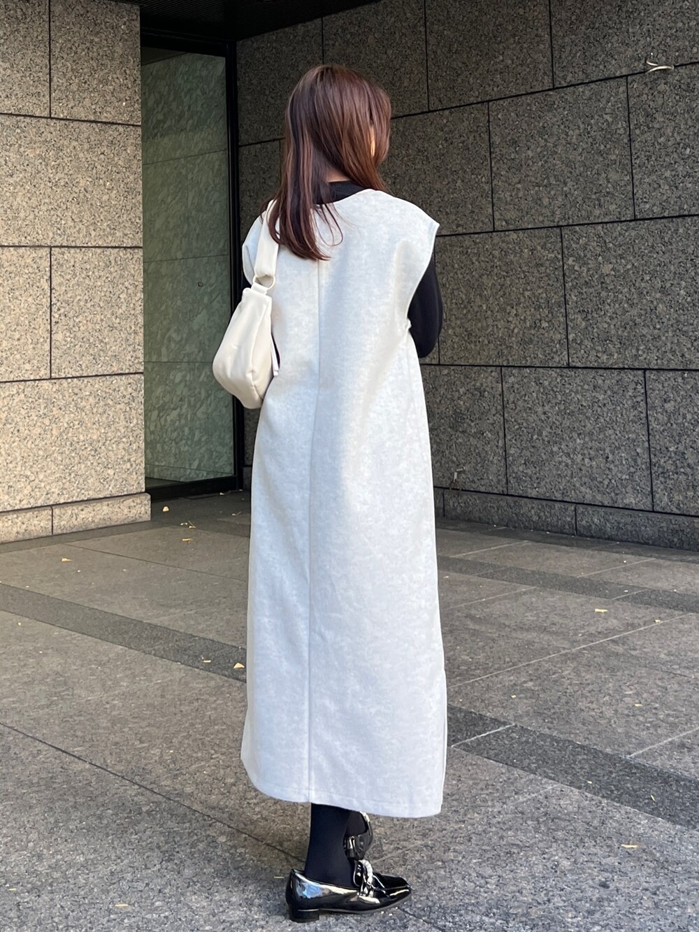 ホワイト系のワンピース、ホワイト系のショルダーバッグ、ブラック系のローファーを着用したレディースの冬コーディネートの3枚目の写真