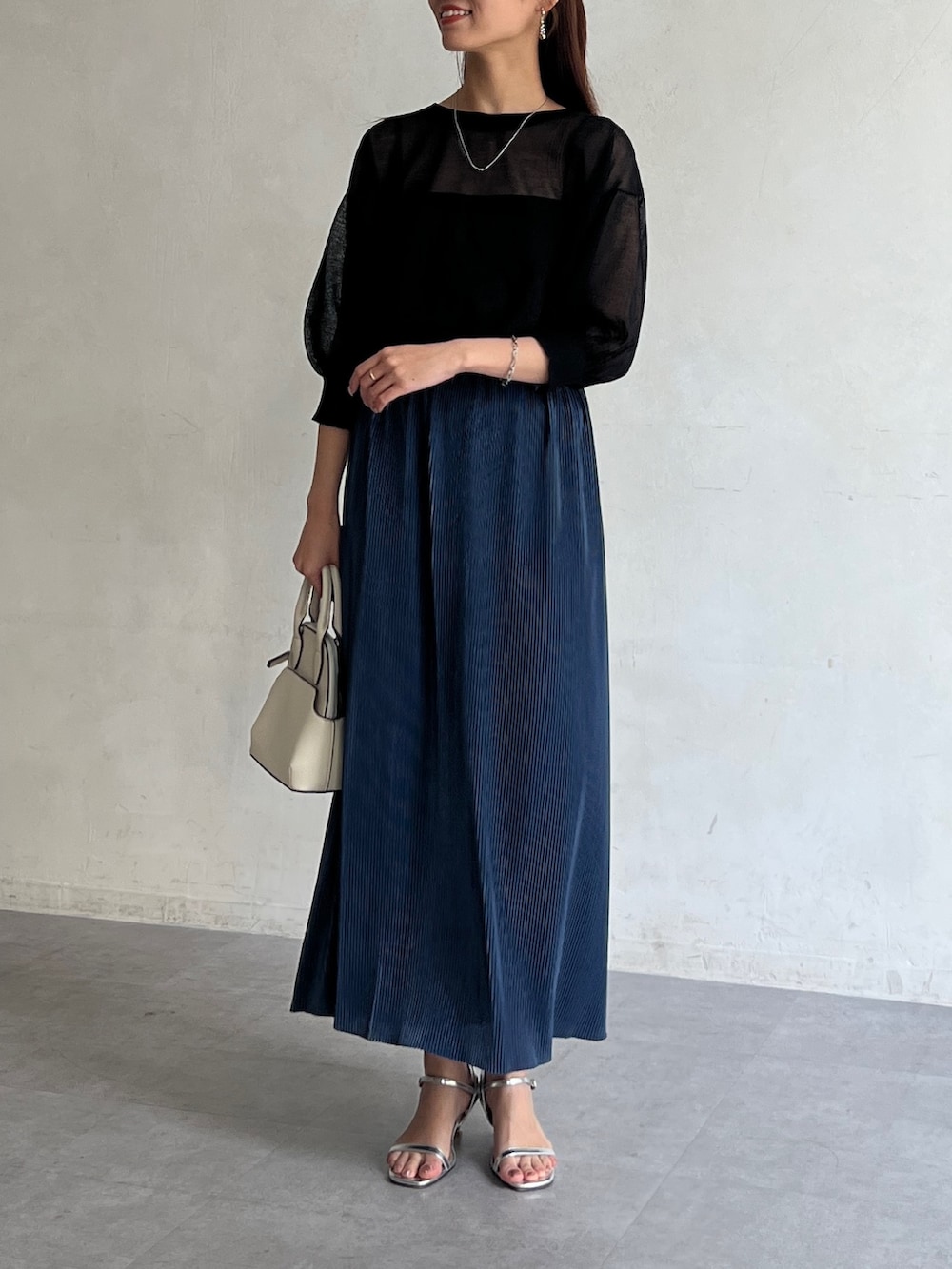 ブラック系のカーディガン/ボレロ、ブルー系のスカート、シルバー系のサンダルを着用したレディースの夏コーディネートの3枚目の写真