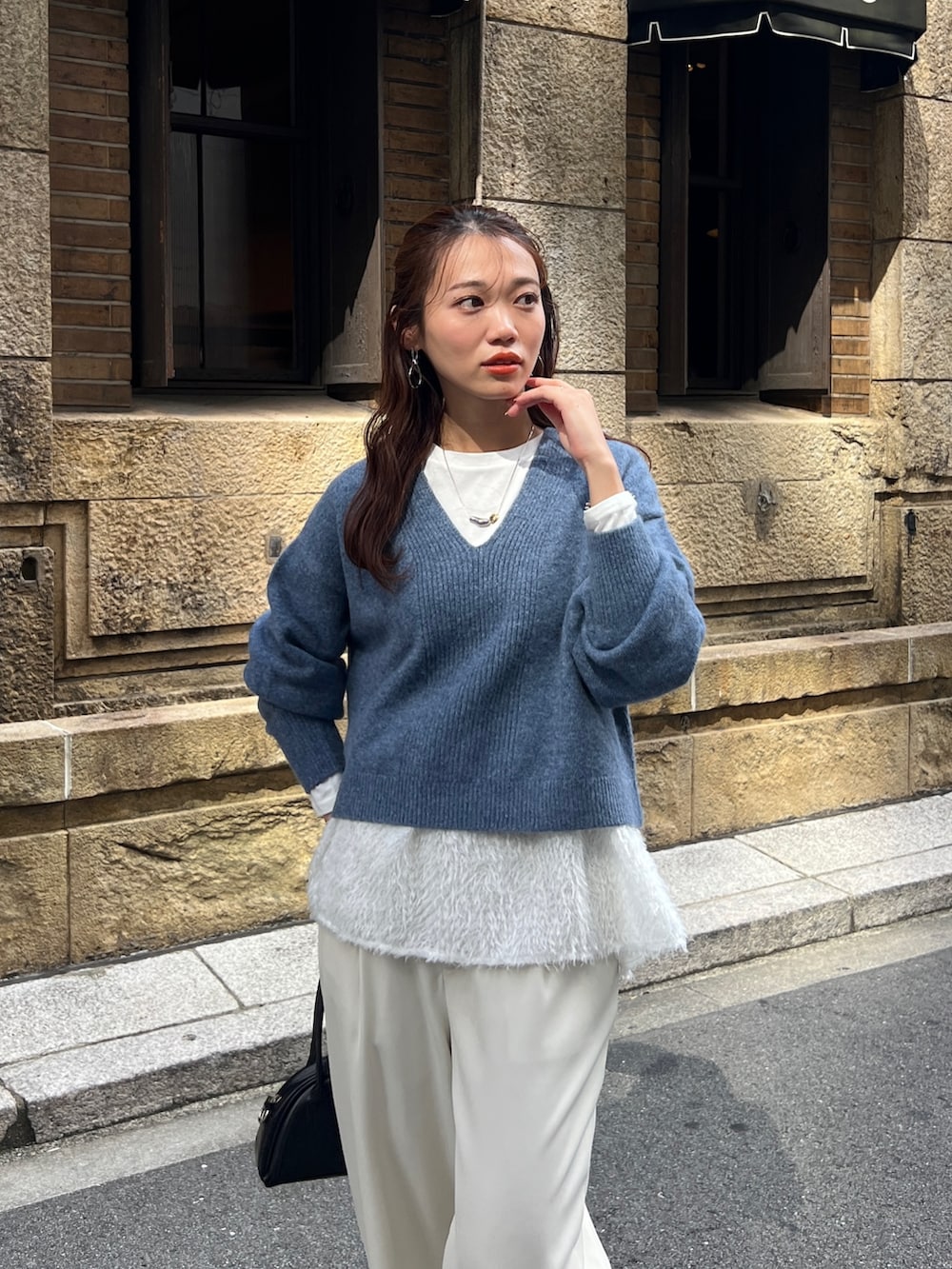 ブルー系のニット/セーター、ブラック系のトートバッグ、ホワイト系のその他パンツを着用したレディースの冬コーディネートの5枚目の写真