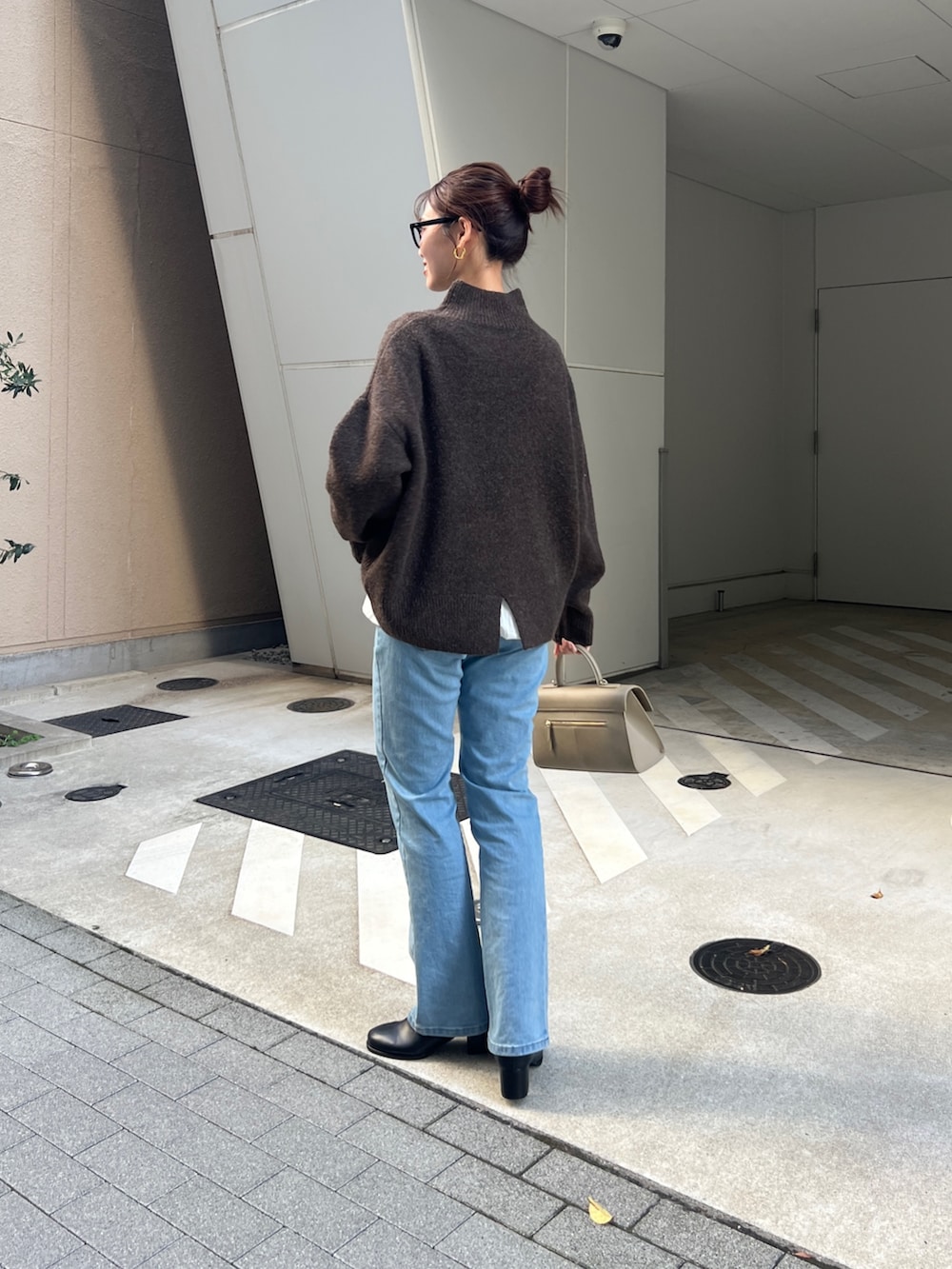 ブラウン系のニット/セーター、グレー系のカーディガン/ボレロ、ブルー系のデニムパンツを着用したレディースの秋コーディネートの3枚目の写真