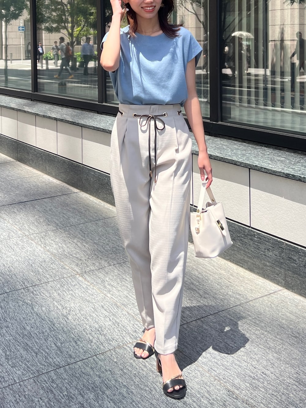 ブルー系のニット/セーター、ベージュ系のその他パンツ、ブラック系のサンダルを着用したレディースの春コーディネートの2枚目の写真