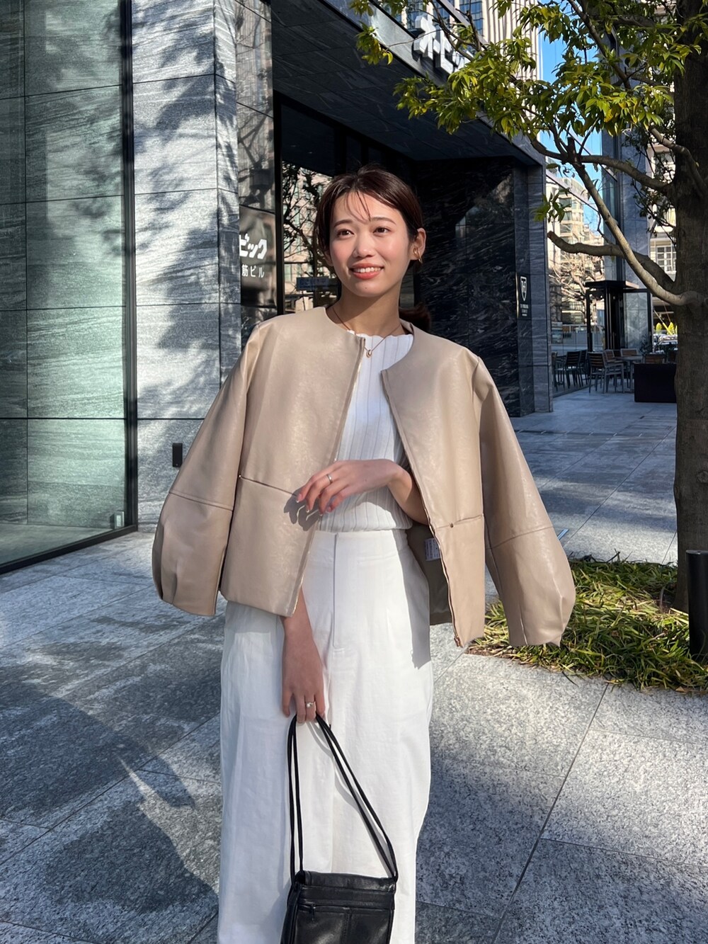 ベージュ系のブルゾン、ホワイト系のニット/セーター、ホワイト系のその他パンツを着用したレディースの春コーディネートの2枚目の写真