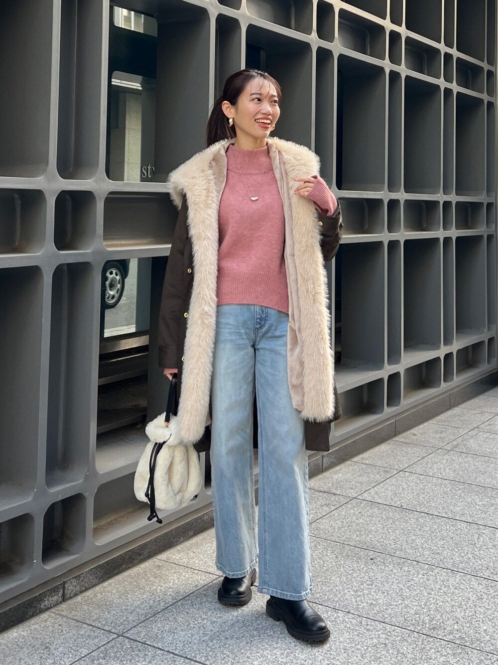 グリーン系のモッズコート、ピンク系のニット/セーター、ブルー系のデニムパンツを着用したレディースの冬コーディネートの3枚目の写真