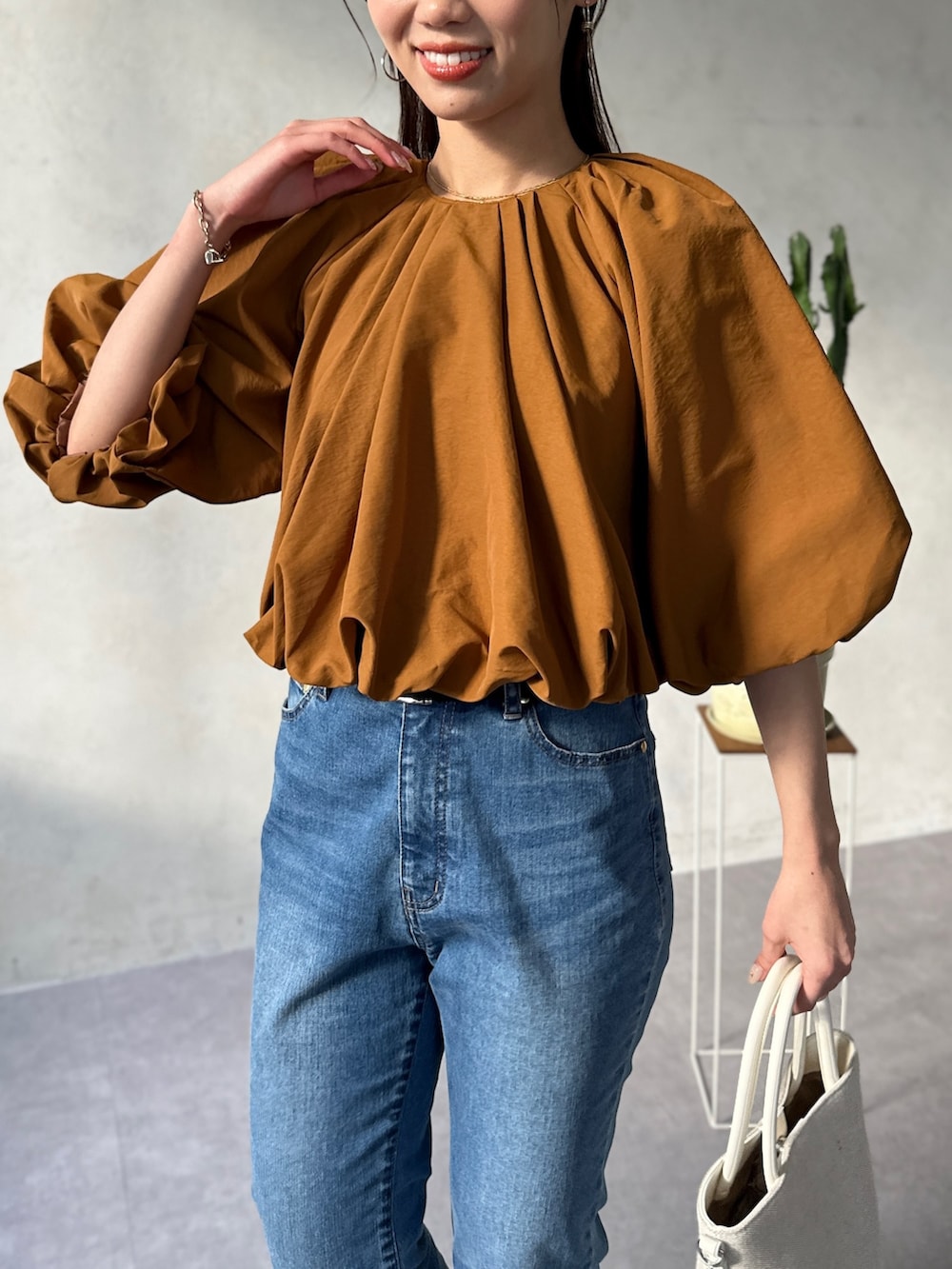 イエロー系のシャツ/ブラウス、ブルー系のデニムパンツ、ホワイト系のトートバッグを着用したレディースの春コーディネートの4枚目の写真