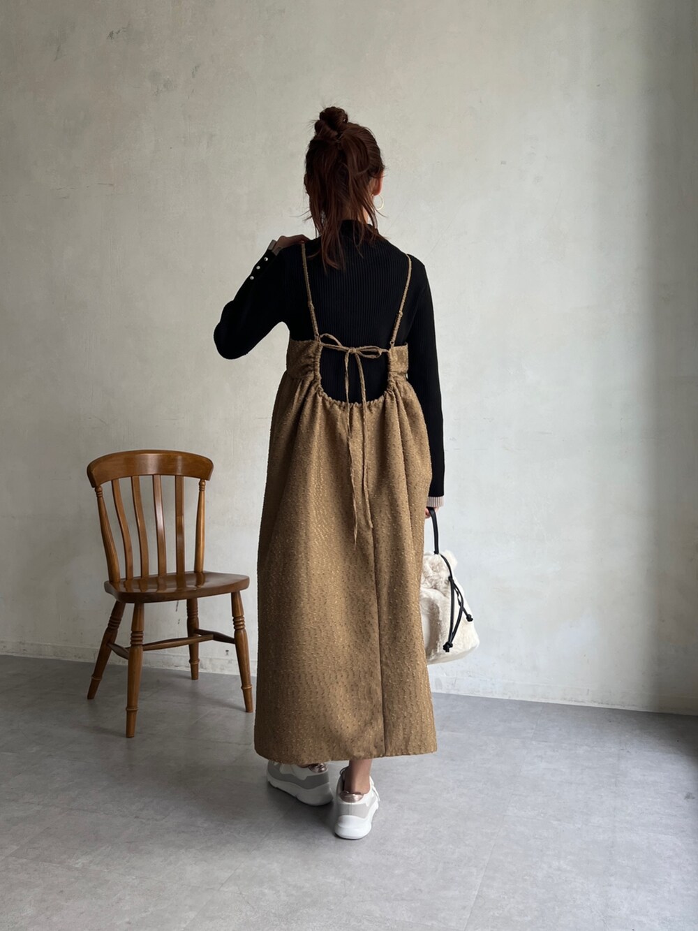 ブラウン系のワンピース、ブラック系のニット/セーター、ホワイト系のトートバッグを着用したレディースの冬コーディネートの3枚目の写真